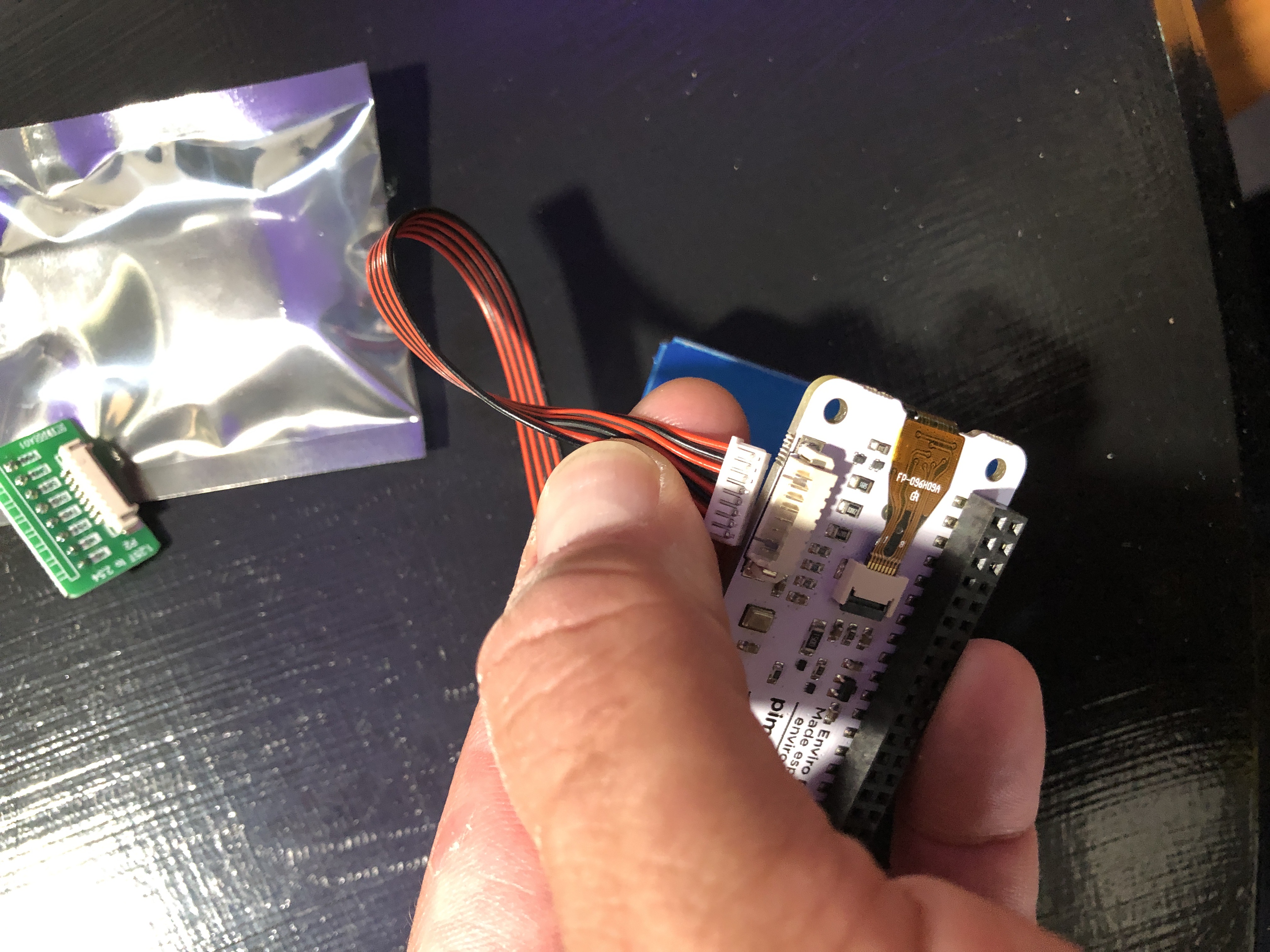 Plug the ribbon cable into the bottom of the Enviro+ Sensor with the side of the plug with the lines/metal up perpendicular to the pins closest to the edge.
