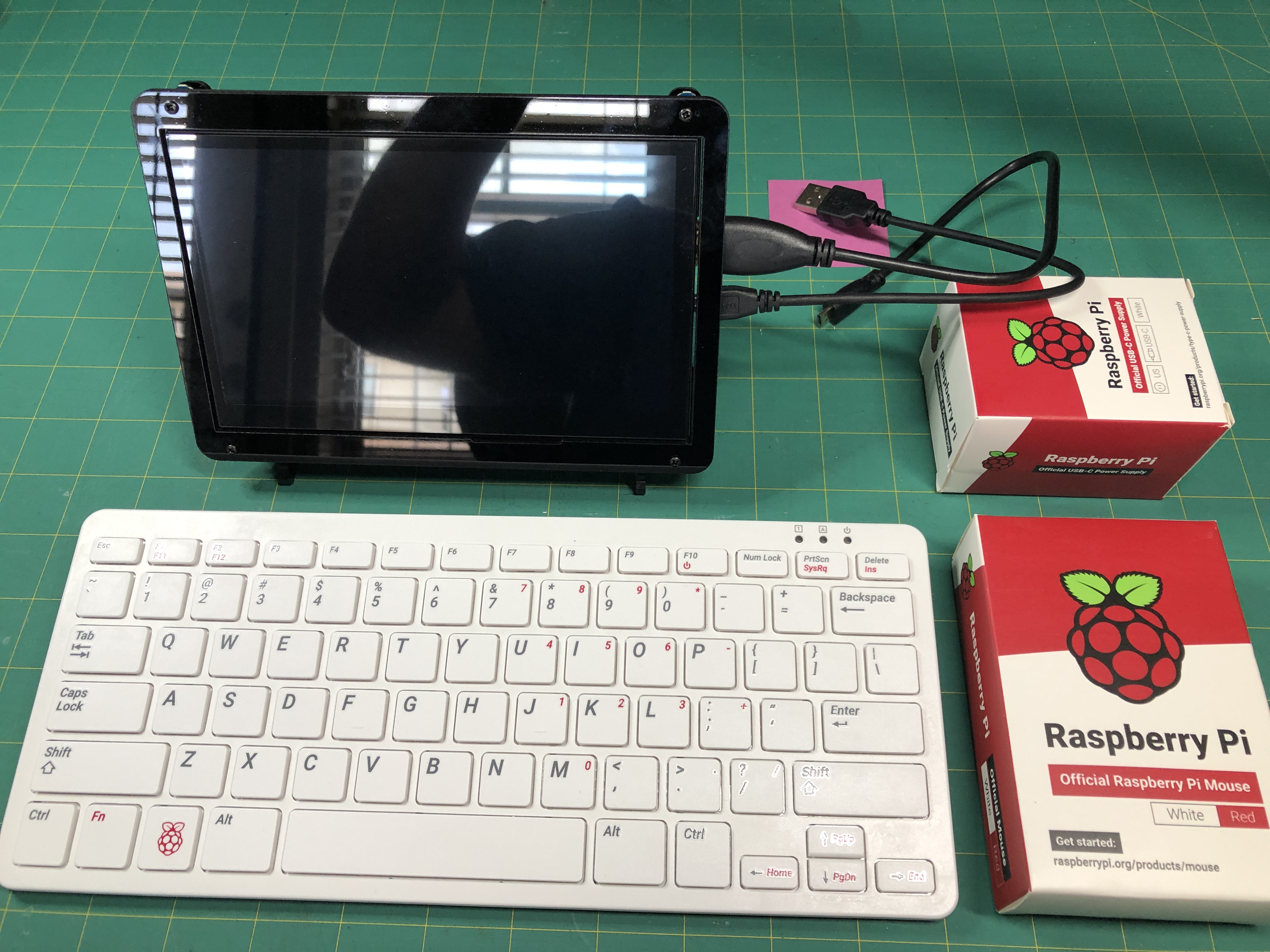 RPi 400 on desk with attached keyboard, mouse, and 7in Screen